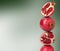 Stack of pomegranate fruits on dark green gradient background, space for text