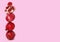 Stack of pomegranate fruits on pink background, space for text