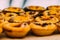 Stack of Portuguese egg tart also known as Pasteis de Nata on display in front of shop