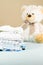 Stack of pressed, ironed newborn baby clothes  with a plush teddy bear