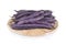 Stack of purple beans on rattan tray and white background