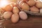 Stack of raw eggs in natural basket on wood table