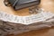 A stack of receipts in the Foreground with Coins and Accordion Folder Organizer in Background