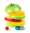 Stack of ripe fruit slices with vitamins on white background