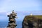 Stack of rocks with the O`Brien tower at the Cliffs of Moher out of focus in the background