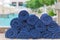Stack roll of bath blue towels on table at swimming pool