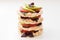 Stack of round crispbreads with cheese, tomatoes, avocado and basil
