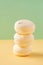Stack of round yellow marshmallows on bicolor pastel background