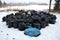 Stack rubbish trash full plastic sacks on snow in park