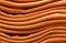 Stack of russet orange woolen knitted sweaters close-up, texture, background