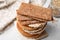 Stack of rye crispbreads, rice cakes and rusks on white table, closeup