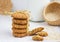 Stack of sesame cookies, sesame seeds in a wicker basket on rough woven tablecloth