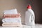 Stack of several coloured and white towels and bottle with cosmetic product