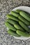 A stack of several fresh green cucumber gherkins in a plate