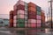 stack of shipping containers near a warehouse building