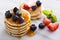 Stack of small pancakes with berries