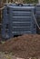 A stack of soil in front of the composter