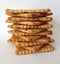 Stack of square salty crackers on white background