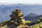 Stack of stones covered with moss on top of a mountain on mountains background. Concept of balance and harmony. Stack of zen rocks