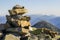 Stack of stones covered with moss on top of a mountain on mountains background. Concept of balance and harmony. Stack of zen rocks