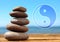 Stack of stones on wooden table outdoors and Ying Yang symbol. Feng Shui philosophy