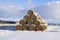 Stack of straw round shape under the layer of snow