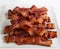 Stack of strips of bacon on a white background