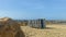 Stack of sun loungers on the sandy beach on the background of a not very stormy sea and the waves of which break on the breakwater