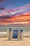 A stack of sun loungers stand on the beach