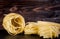 Stack of tagliatelle pasta nests over dark wooden background