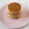 Stack of tasty Dutch stroopwafels with honey-caramel filling on a pink plate, low angle view