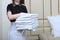 A stack of Terry towels in the hands of a maid. The concept of cleaning and cleanliness in the room. Copy of the space.