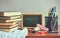 Stack of textbooks, school accessories on wooden table