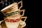 Stack of three elegant, classic style, gilded tea cups on a dark background