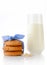 Stack of three homemade oatmeal cookies tied with blue ribbon in small white polka dots, ear of oats and glass of milk