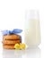 Stack of three homemade oatmeal cookies tied with blue ribbon in small white polka dots, tiny yellow flowers and glass of milk