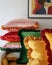 A stack of three striped pillows with curled edges, displayed on a shelf