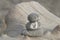 Stack of three stripy pebbles on a driftwood log