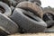 A stack of tires on an old garbage dump. Old worn out tires pile