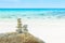 Stack tower of stone balances on a beach with water sea and blue sky nature