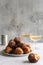 A stack of traditional oliebollen (Dutch dough fritters) with a glass of champagne on white background