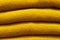 Stack of trend Ceylon yellow woolen knitted sweaters close-up, texture, background