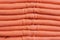 Stack of trend Living Coral woolen sweaters close-up, texture, background