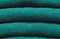 Stack of trend Quetzal Green woolen sweaters close-up, texture, background