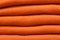 Stack of trend Russet Orange woolen sweaters close-up, texture, background
