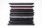 Stack of used laptops in different colors and models. T