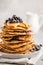 Stack vegan blueberry pancakes with peanut butter and syrup.