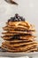 Stack vegan blueberry pancakes with peanut butter and syrup.