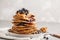 Stack vegan blueberry pancakes with peanut butter and syrup.