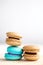 Stack of Vibrant colorfull macarons on white wooden table.